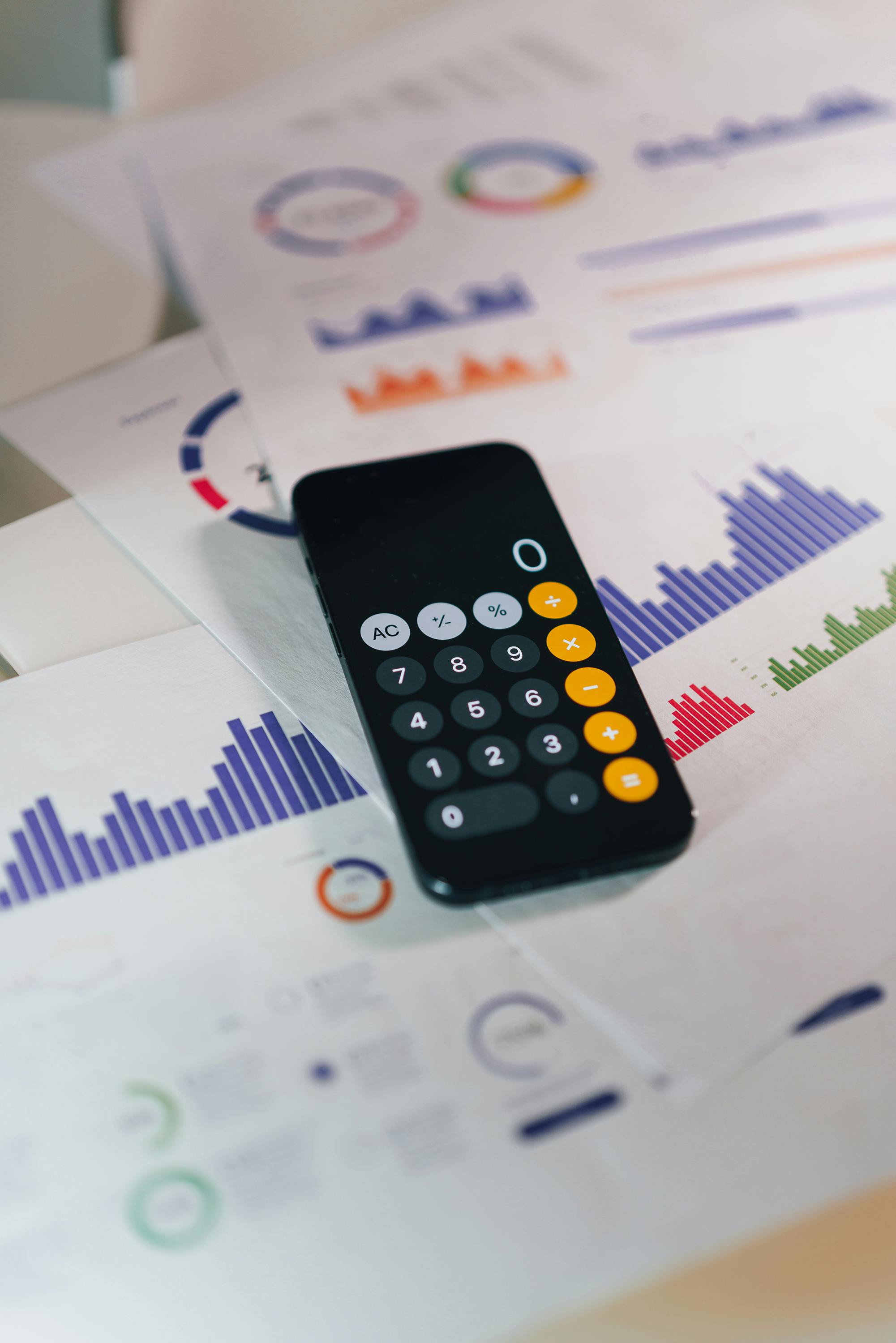 image of an iphone calculator with not-for-profit financial reports on a desk